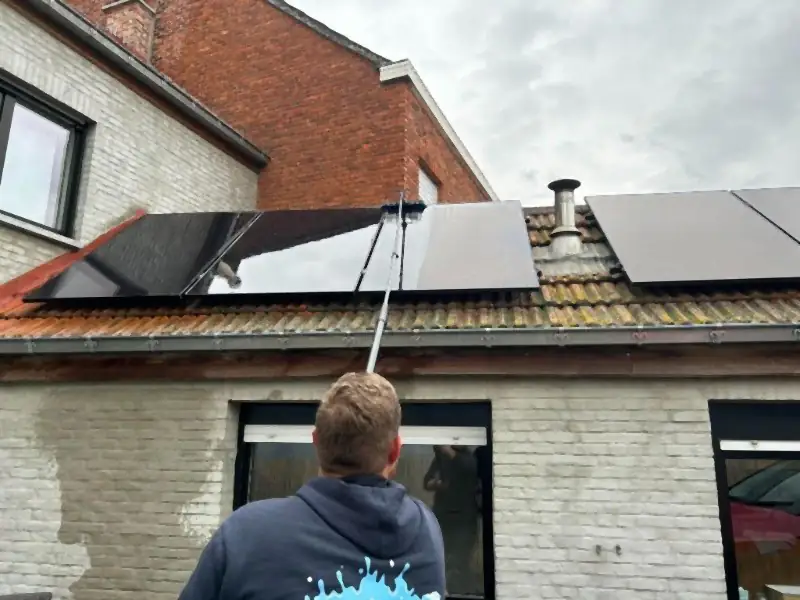 Zonnepanelen op een pannendak worden gereinigd met een telescoopsteel
